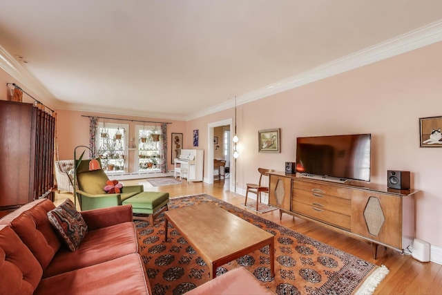 living area featuring ornamental molding, wood finished floors, and baseboards