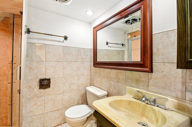 5058 S Ridgeway Ave, Chicago, IL 60632 - bathroom featuring tile walls, vanity, and toilet