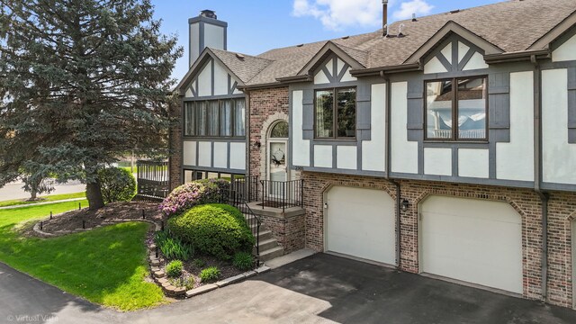 2305 Olde Mill Rd Unit 2305, Plainfield, IL 60586 - tudor home featuring brick siding, a chimney, roof with shingles, and stucco siding