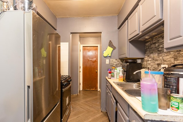 kitchen with light countertops, gray cabinets, stainless steel appliances, and a sink