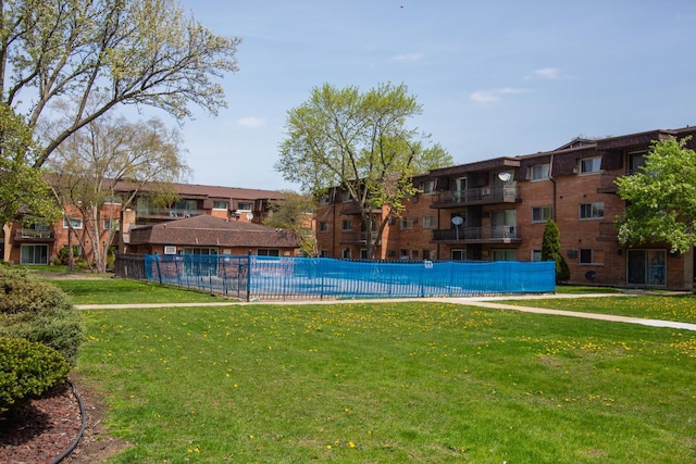 pool featuring fence and a yard