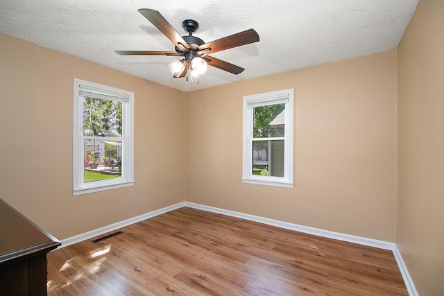 566 N 10th Ave, Kankakee, IL 60901 - unfurnished room with baseboards, healthy amount of natural light, wood finished floors, and a textured ceiling