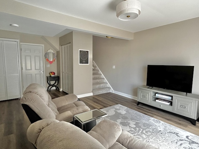living room featuring stairway, baseboards, and wood finished floors