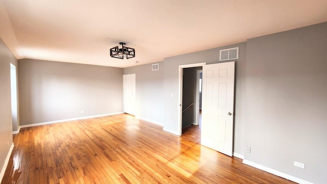 spare room featuring baseboards, visible vents, and light wood-style floors