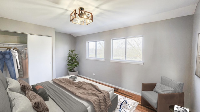 bedroom with baseboards, wood finished floors, and a closet