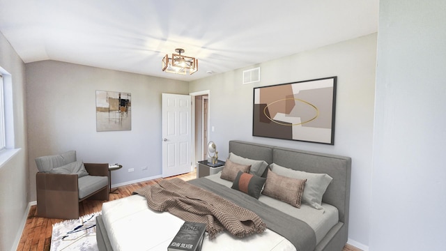 bedroom with baseboards, wood finished floors, and visible vents