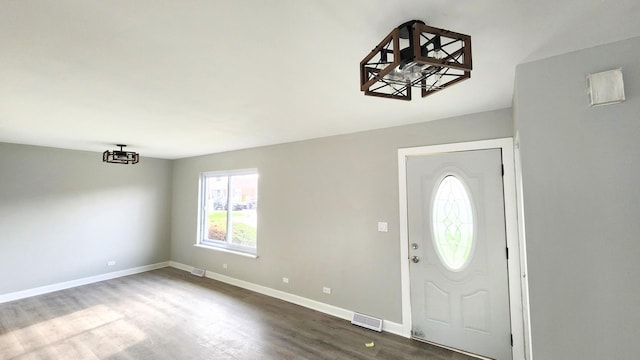 foyer featuring baseboards, dark wood-style flooring, and visible vents