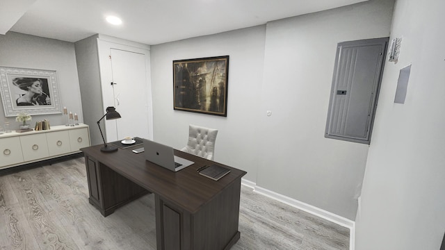office area with recessed lighting, baseboards, electric panel, and light wood-style floors