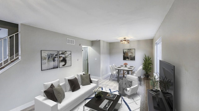 living room with an inviting chandelier, baseboards, and visible vents
