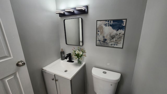 half bath featuring vanity and toilet