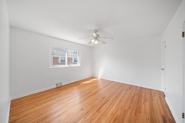 unfurnished room with light wood-type flooring, a ceiling fan, baseboards, and visible vents