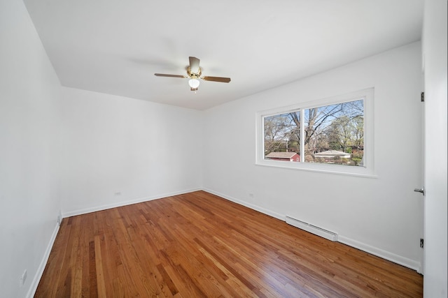 unfurnished room featuring baseboards, ceiling fan, baseboard heating, and wood finished floors