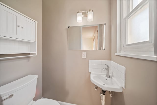 bathroom featuring a sink, a healthy amount of sunlight, and toilet