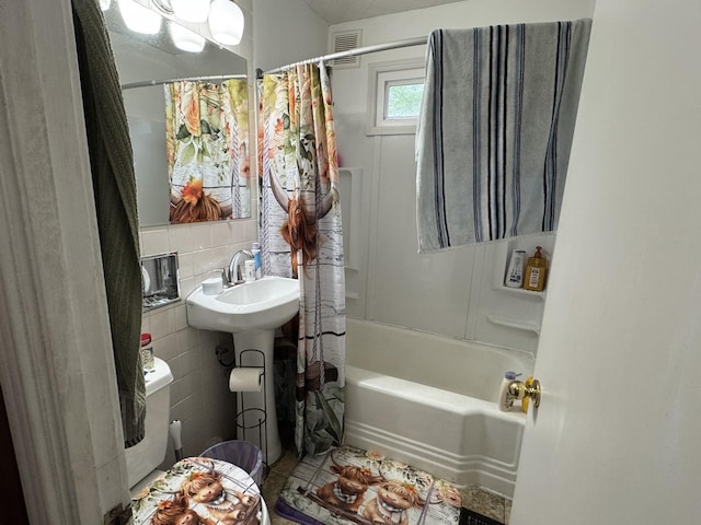 bathroom with visible vents, shower / bathtub combination with curtain, and tile walls