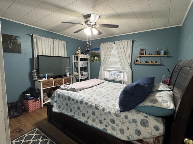 bedroom featuring crown molding, ceiling fan, and dark wood-style flooring