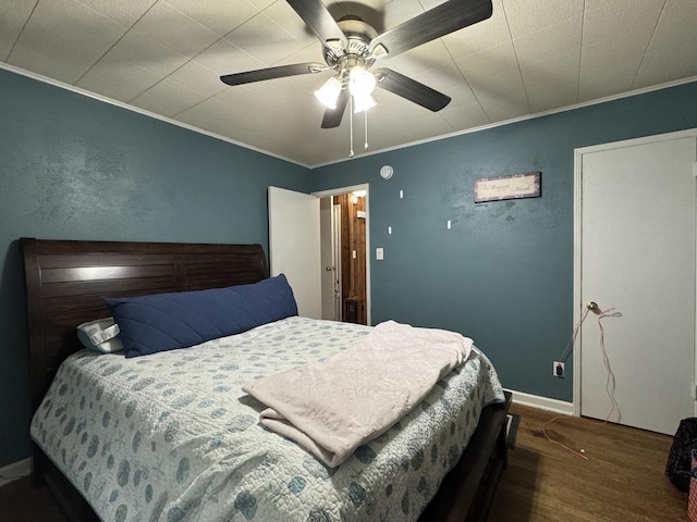 bedroom featuring ceiling fan, ornamental molding, and wood finished floors