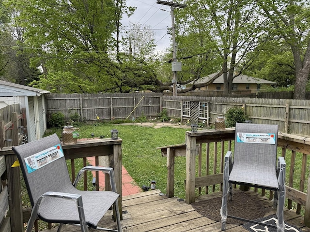 wooden terrace with a fenced backyard, an outbuilding, and a yard