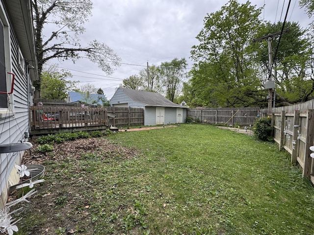 view of yard with a fenced backyard, an outbuilding, a deck, and a storage shed