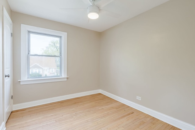 spare room featuring light wood-style floors, a ceiling fan, and baseboards