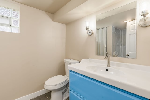 full bath with vanity, baseboards, a shower, and toilet