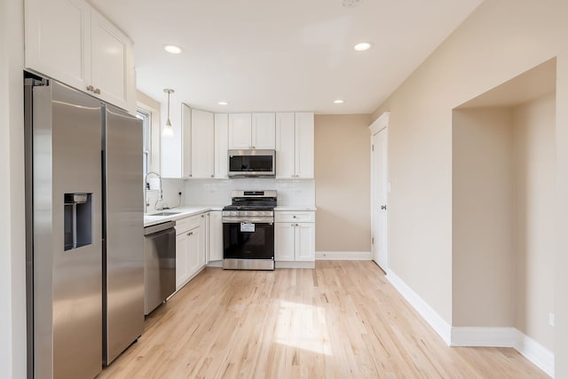 kitchen featuring white cabinets, appliances with stainless steel finishes, a sink, and tasteful backsplash