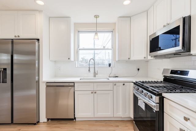 kitchen with a sink, appliances with stainless steel finishes, and white cabinetry