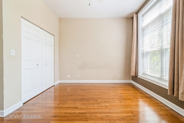unfurnished bedroom with light wood-style floors, a closet, and baseboards