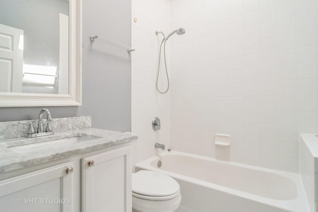 bathroom featuring toilet, vanity, and bathing tub / shower combination