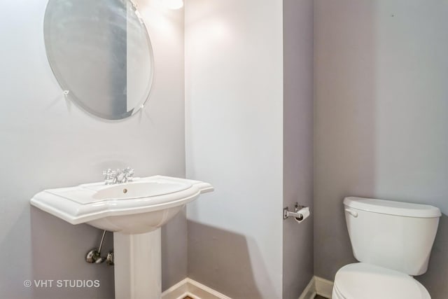 bathroom with toilet and baseboards