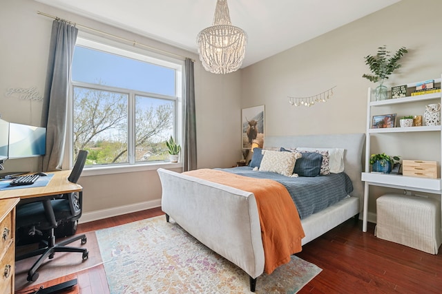 bedroom with baseboards, wood finished floors, a notable chandelier, and multiple windows