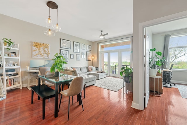 dining space with baseboards, ceiling fan, and wood finished floors