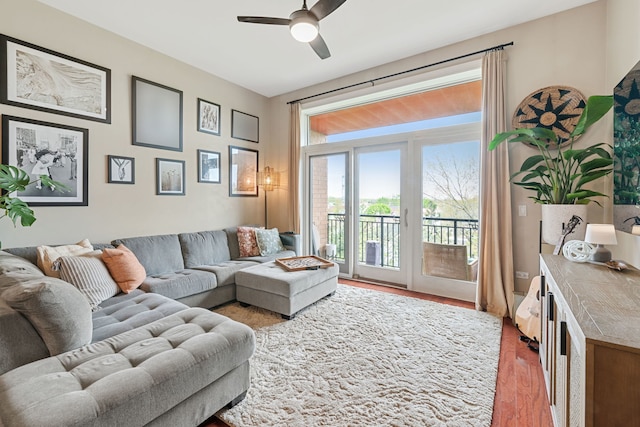 living room with light wood-type flooring and a ceiling fan