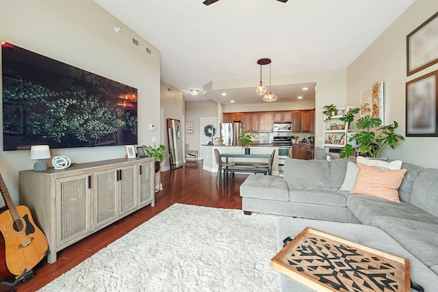 living area with a ceiling fan and dark wood finished floors
