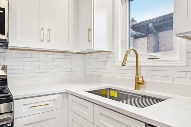 310 Muskegon Ave, Calumet City, IL 60409 - kitchen with light countertops, white cabinetry, a sink, and backsplash