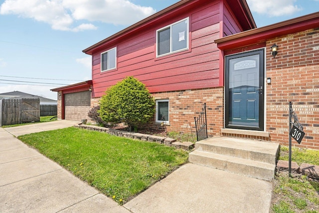 310 Muskegon Ave, Calumet City, IL 60409 - entrance to property with fence, a yard, concrete driveway, and brick siding
