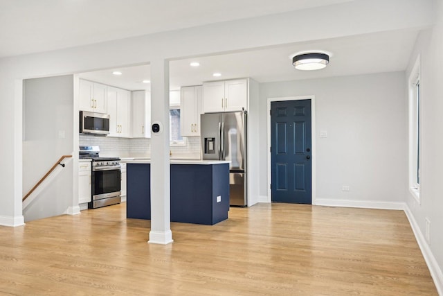 310 Muskegon Ave, Calumet City, IL 60409 - kitchen featuring white cabinets, appliances with stainless steel finishes, light countertops, a center island, and tasteful backsplash