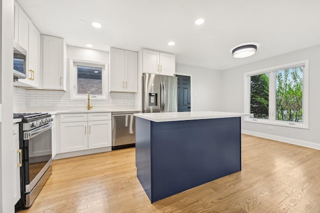 310 Muskegon Ave, Calumet City, IL 60409 - kitchen with appliances with stainless steel finishes, a sink, light countertops, a center island, and decorative backsplash