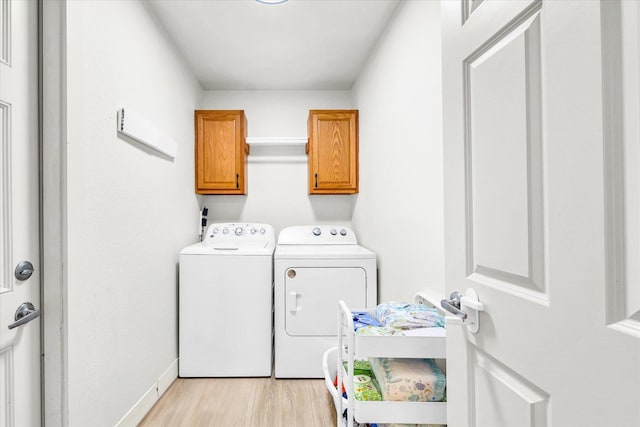 4022 Orchard Ln, Monticello, IL 61856 - washroom featuring separate washer and dryer, cabinet space, light wood-type flooring, and baseboards