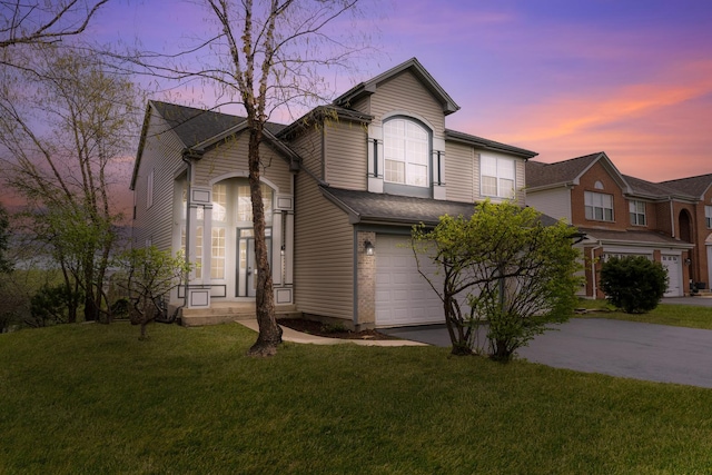 traditional-style house with an attached garage, a front lawn, and driveway