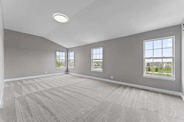 carpeted empty room with baseboards and lofted ceiling