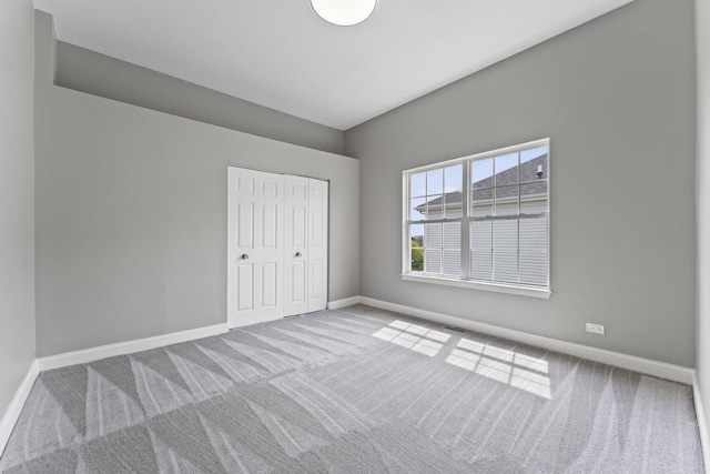 unfurnished bedroom with baseboards, carpet, visible vents, and a closet