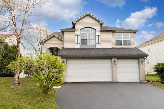 traditional-style home with brick siding, a garage, roof with shingles, and driveway