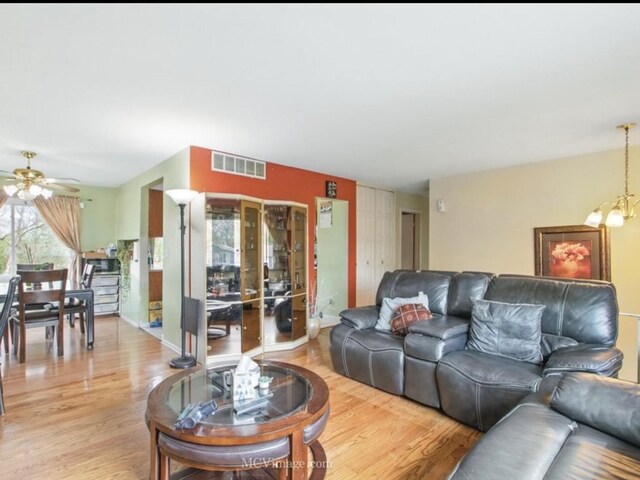224 Lexington Dr, Bolingbrook, IL 60440 - living room featuring visible vents, light wood-style flooring, and ceiling fan with notable chandelier
