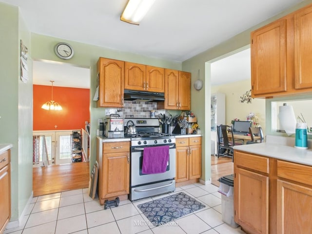 224 Lexington Dr, Bolingbrook, IL 60440 - kitchen with under cabinet range hood, decorative backsplash, stainless steel gas stove, and light countertops