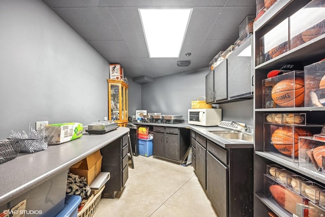 kitchen featuring open shelves, a sink, a paneled ceiling, and white microwave