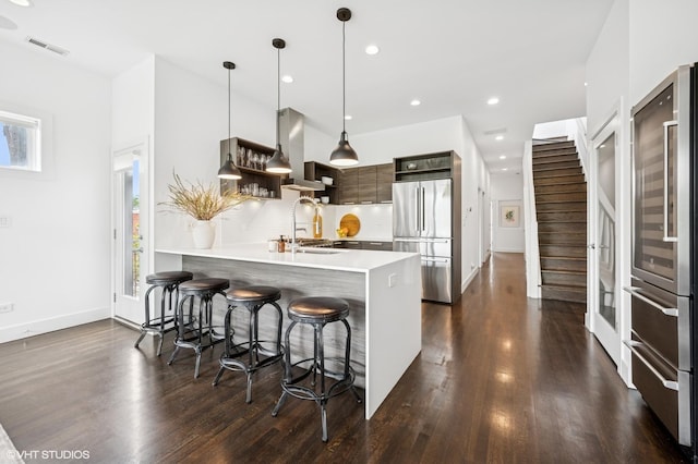 kitchen featuring freestanding refrigerator, a sink, modern cabinets, a peninsula, and light countertops