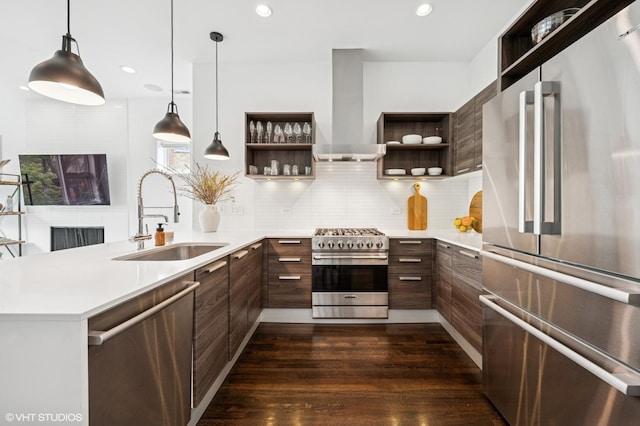 kitchen featuring appliances with stainless steel finishes, open shelves, wall chimney range hood, a sink, and a peninsula
