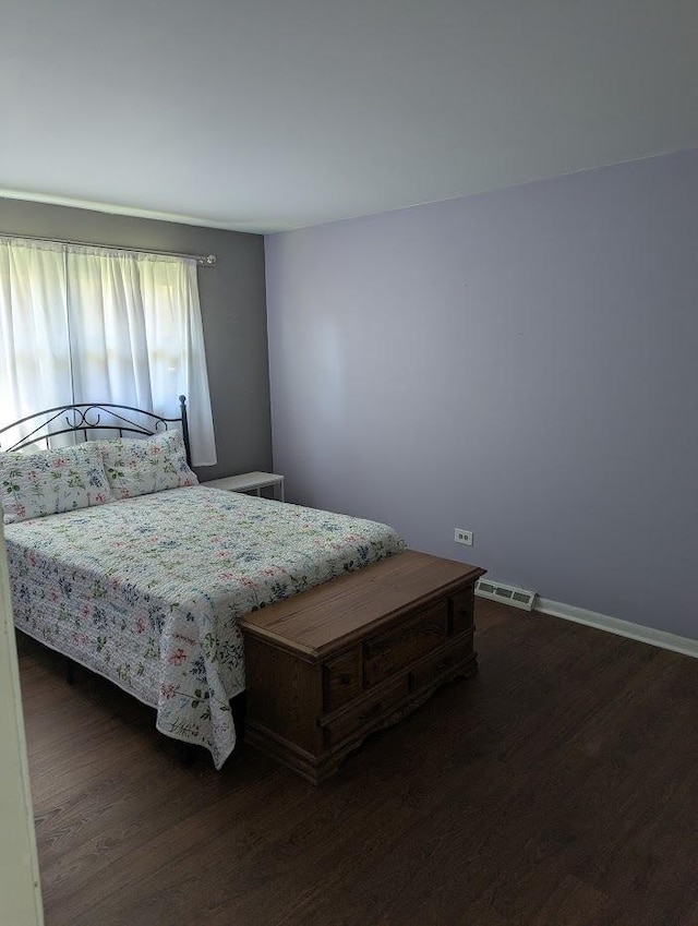 bedroom featuring visible vents, dark wood-style flooring, and baseboards