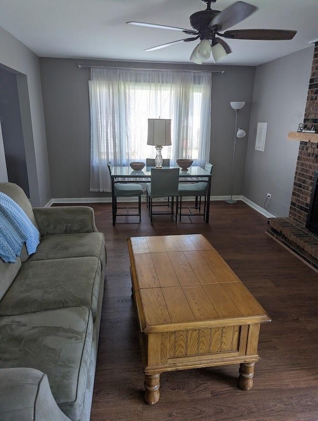 living room featuring baseboards, plenty of natural light, a ceiling fan, and wood finished floors