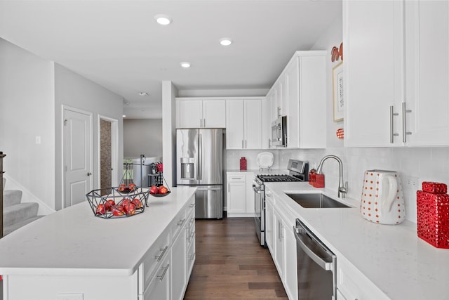 kitchen with a sink, dark wood finished floors, a center island, stainless steel appliances, and white cabinetry
